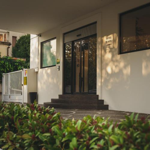 a house with a black door and some bushes at Hotel Morfeo in Milan