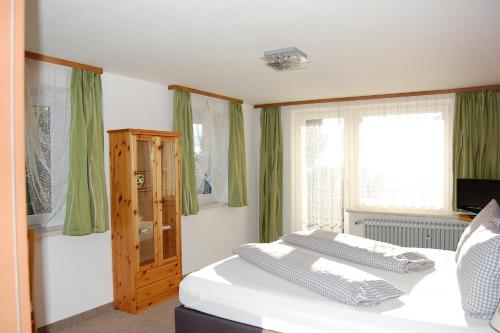 a bedroom with a bed with green curtains at Landhotel Krone in Oberreute