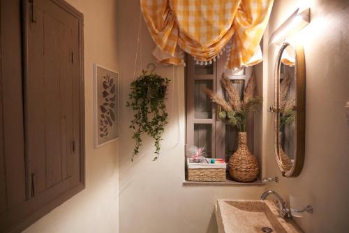 a bathroom with a sink and a window with plants at Dandy Villas Dimitsana - a family ideal charming home in a quaint historic neighborhood - 2 fireplaces for romantic nights in Dimitsana