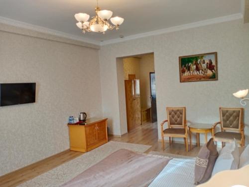 a living room with a table and chairs and a chandelier at Hotel Asia Bukhara in Bukhara