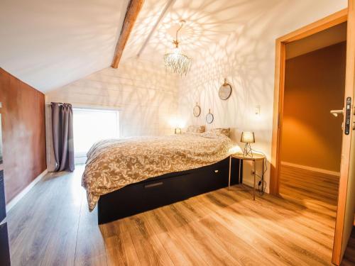 sypialnia z łóżkiem i drewnianą podłogą w obiekcie Beautiful holiday home in Fays with garden w mieście Fays