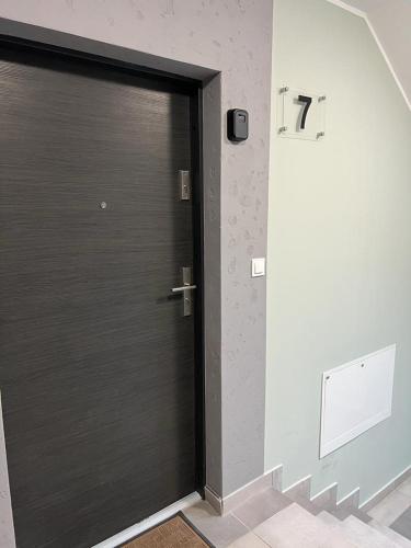 a black door in a room with a wall at Kawalerka Wałowa 7 in Wejherowo