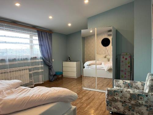 1 dormitorio con espejo, 1 cama y 1 silla en Bright Guesthouse in the center of Yerevan!, en Ereván
