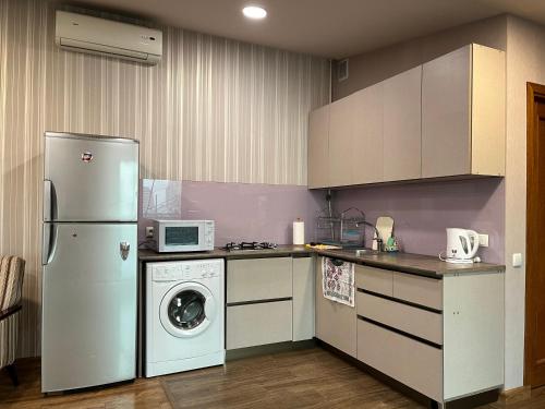 een keuken met een koelkast en een wasmachine bij Bright Guesthouse in the center of Yerevan! in Jerevan