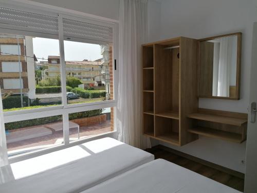 a bedroom with a large window and a bed and a windowpect at Apartamentos Regollera Premium con garaje in Noja