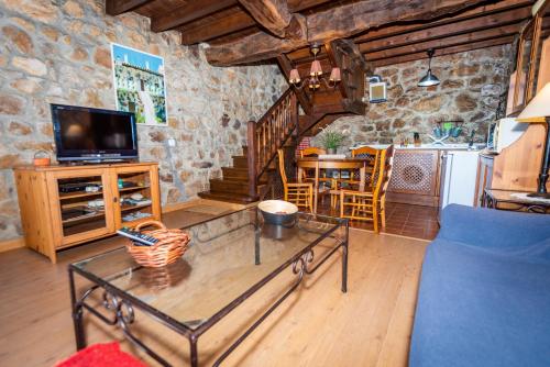 sala de estar con mesa de centro y cocina en Casa Tenada, en Robledo