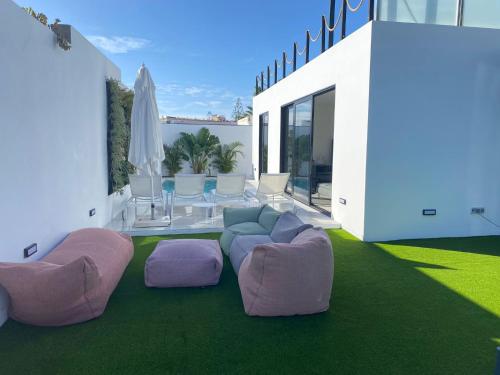 un soggiorno con tavolo e sedie viola e rosa di Cap-Canaria FKK a San Bartolomé