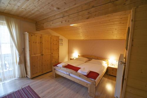 ein Schlafzimmer mit einem großen Bett und einer Holzdecke in der Unterkunft Gasthof Alpl in Sirnitz