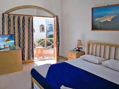 Red Sea Relax Hotel في دهب: غرفة نوم بسرير وباب للباحة