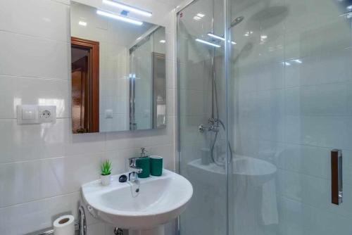 y baño blanco con lavabo y ducha. en Hermanos Pinzón Apartamento, en Zamora