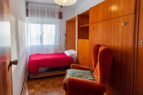 1 dormitorio con 1 cama roja y 1 silla en Hermanos Pinzón Apartamento, en Zamora