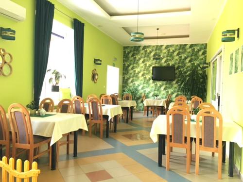 Hotel Na Wzgórzu في غنياو: مطعم به طاولات وكراسي وتلفزيون على الحائط