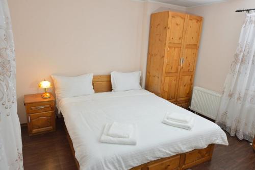 een slaapkamer met een bed met twee handdoeken erop bij Зелената Къща 