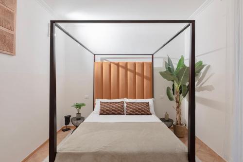 an iron canopy bed in a bedroom with a plant at A World Aparts - 21 T. Argentina in Rome
