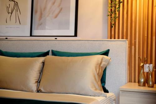 łóżko z zielonymi i białymi poduszkami w pokoju w obiekcie maison jamouri w mieście Kríni