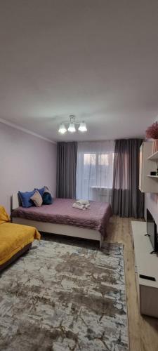 um quarto com uma cama grande e uma janela em Apart рядом с MEGA Аlma-Ata em Almaty