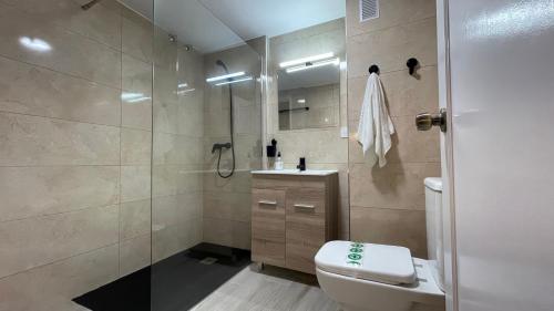 y baño con ducha, aseo y lavamanos. en suite benal beach 23, en Benalmádena