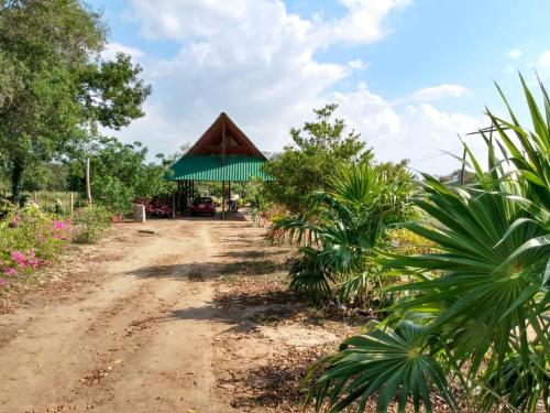 a dirt road leading to a building with a green roof at Cabaa De Descanso, Isla De Bar - Cartagena - Rest Cabin, Baru Island -Bolivar in Playa Blanca