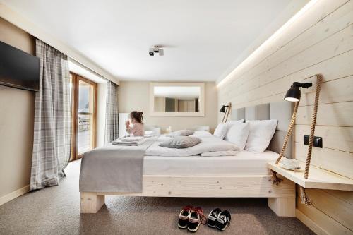 una mujer sentada en una cama grande en un dormitorio en VILLA NOSAL - Zakopane, en Zakopane