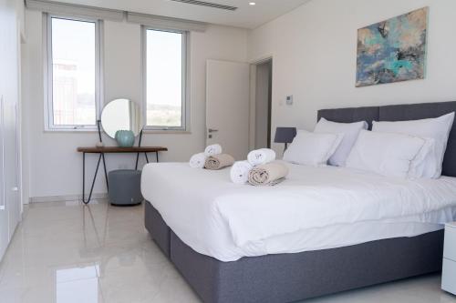 um quarto com uma grande cama branca com toalhas em Vivo Mare Beachfront Villas - Vista em Agia Napa