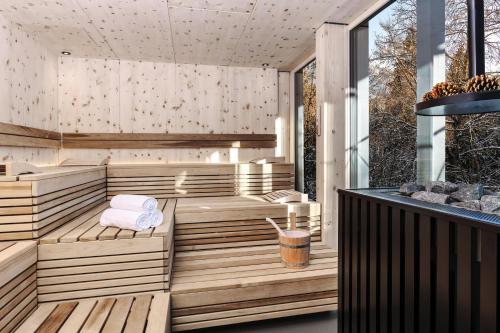 Romantik Hotel Schweizerhof & Spa في فليمس: ساونا في الهواء الطلق مع مقاعد ومناشف خشبية