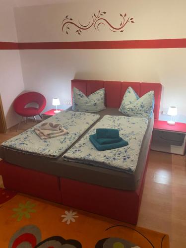Haus Zeichner 2 Zimmer Ferienwohnung في فيلدبرج: سرير مع اللوح الأمامي الأحمر في الغرفة