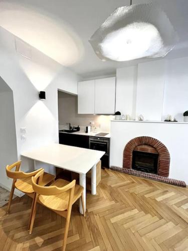 - une cuisine blanche avec une table et une cheminée dans l'établissement LE MÉDITERRANÉEN - Terrasse - Parking, à Montpellier