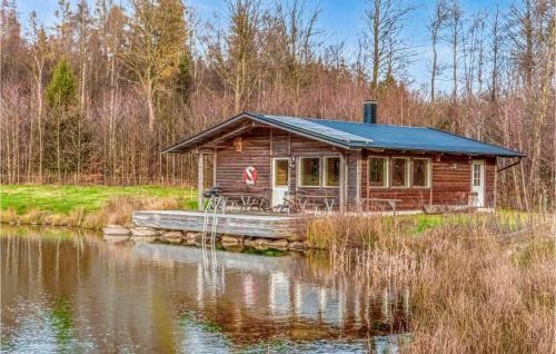 una cabaña de madera en el agua cerca de un lago en Gorgeous Home In Hrby With House Sea View, en Hörby