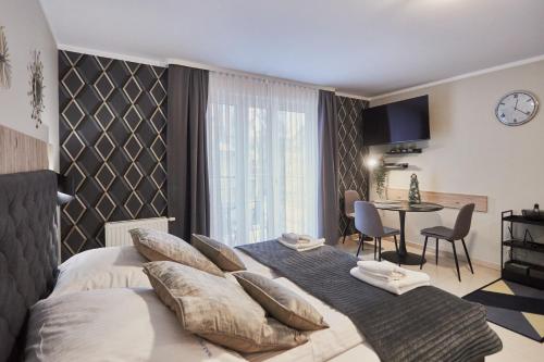 um quarto de hotel com uma cama e uma sala de jantar em Avangard by Baltic Home em Świnoujście