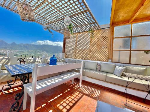 a balcony with a bench and a table and a view at Darna Hostel in Tetouan
