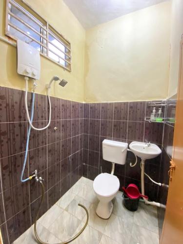a bathroom with a toilet and a sink at Naufa Homestay 2 3R3B Machang in Macang