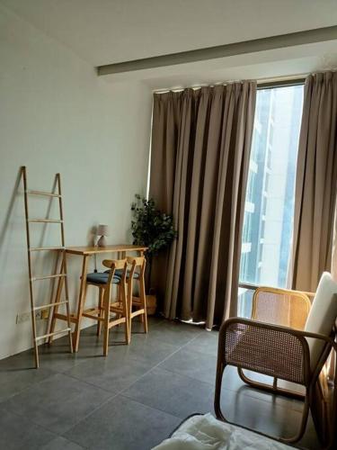 ein Wohnzimmer mit einem Tisch, Stühlen und einem Fenster in der Unterkunft Simple studio @ Empire damansara in Petaling Jaya