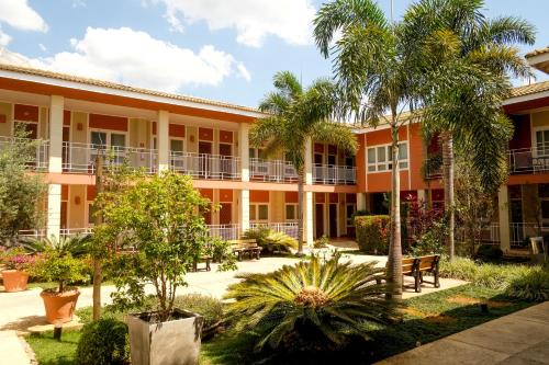 zewnętrzny widok na budynek z drzewami i roślinami w obiekcie Atibaia Residence Hotel & Resort w mieście Atibaia