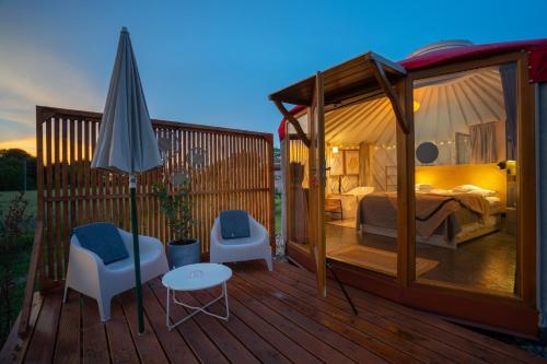 un gazebo con una camera da letto e un letto su una terrazza di Izera Glamping Adults - Luksusowe jurty&spa (adults only) a Gajowka