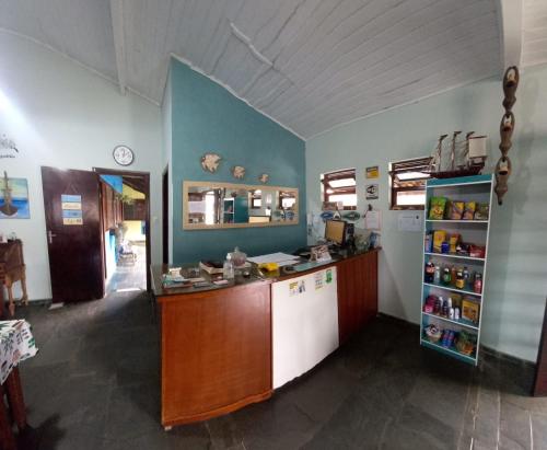 a kitchen with a counter and a refrigerator at Pousada Chalé do Beija Flor in Ubatuba