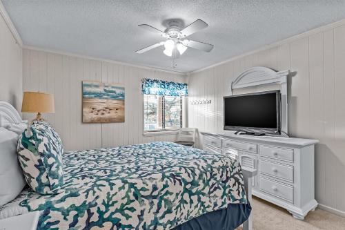 1 dormitorio con 1 cama y TV de pantalla plana en Ocean Isle Retreat, en Ocean Isle Beach