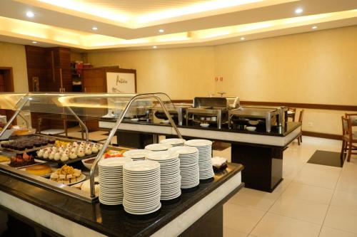 a buffet line with plates and appetizers in a restaurant at Atibaia Residence Hotel & Resort in Atibaia