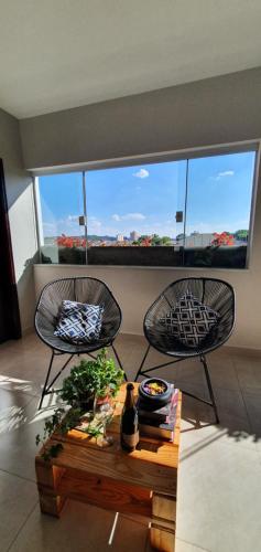 two chairs and a table in a room with a window at Casa Romão I - Charme perto de Vinícola e Centro in Espirito Santo Do Pinhal