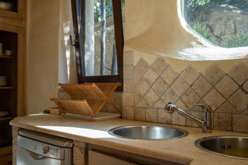 a kitchen counter with a sink and a window at Lussuosa villa con Piscina opera dell'Arch.Couelle in Porto Cervo