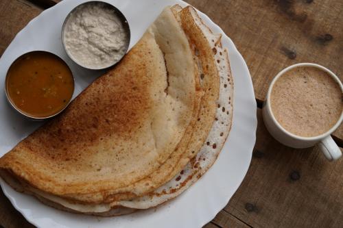 a plate of food with two pancakes and a cup of coffee at North Centre in Cochin