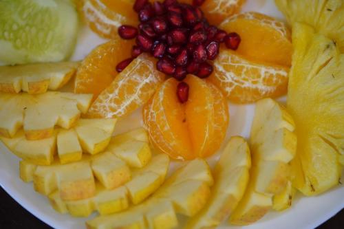 a plate of fruit with oranges oranges and pomegranates at North Centre in Cochin