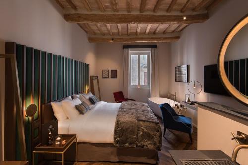 a hotel room with a large bed and a bathroom at Times Suites & Bar in Perugia