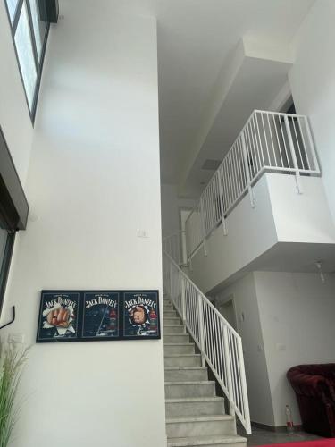 a white staircase in a room with a couch at פנטהוז ונוף עוצר נשימה, שקט אפשרות בקומה העליונה לחדר משרד הפנטהוז מיועד לאורחים in Beit Shemesh
