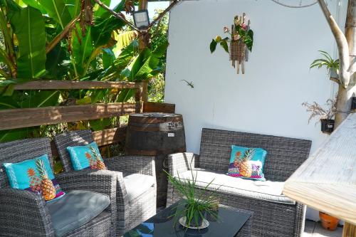 d'une terrasse avec 2 chaises en osier et une table. dans l'établissement Résidence Flores De Maria, au Marin