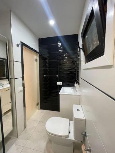 a white bathroom with a toilet and a shower at Happy Space Apartment in Los Cristianos