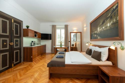 a bedroom with a large bed and a kitchen at Zois Apartments in Ljubljana