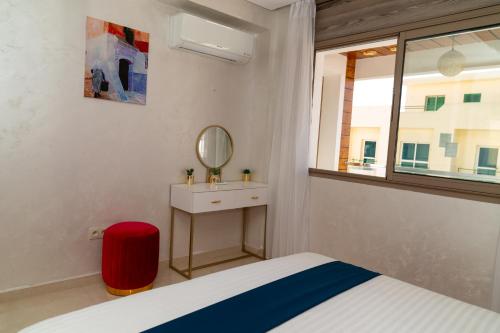 a bedroom with a bed and a sink and a mirror at PUERTO MARINA ASILAH in Asilah