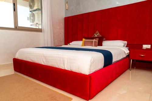 a large bed with a red headboard in a bedroom at PUERTO MARINA ASILAH in Asilah