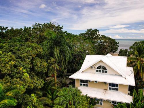 una casa amarilla con techo blanco y árboles en Santuarios del Mar, en Bocas Town