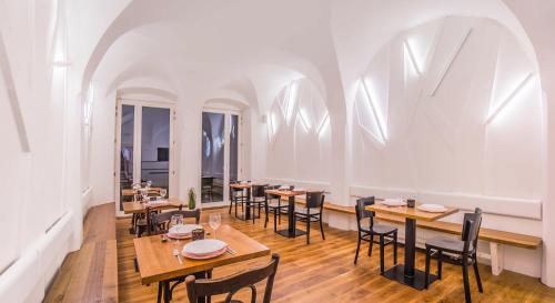 a restaurant with wooden tables and chairs and windows at Penzion a Restaurace 14 in Hostinné